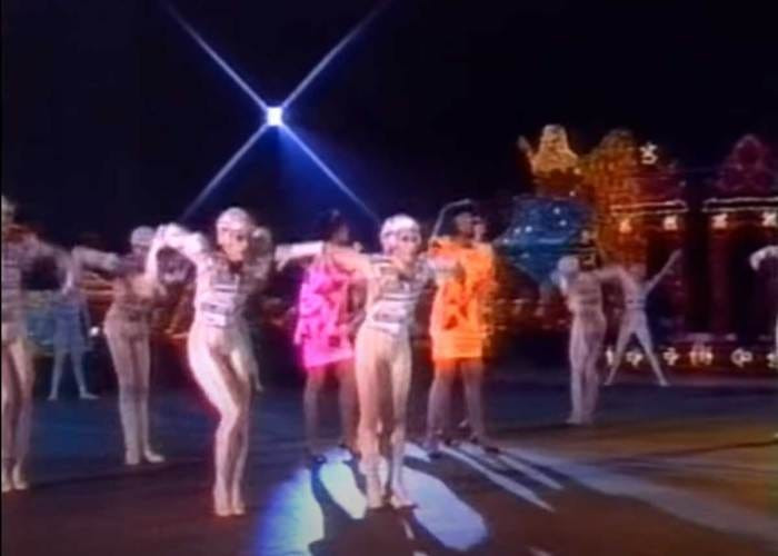A group of dancers in black and blue light-up costumes, possibly inspired by TRON, perform the Neutron Dance during the Disneyland 30th Anniversary TV special.