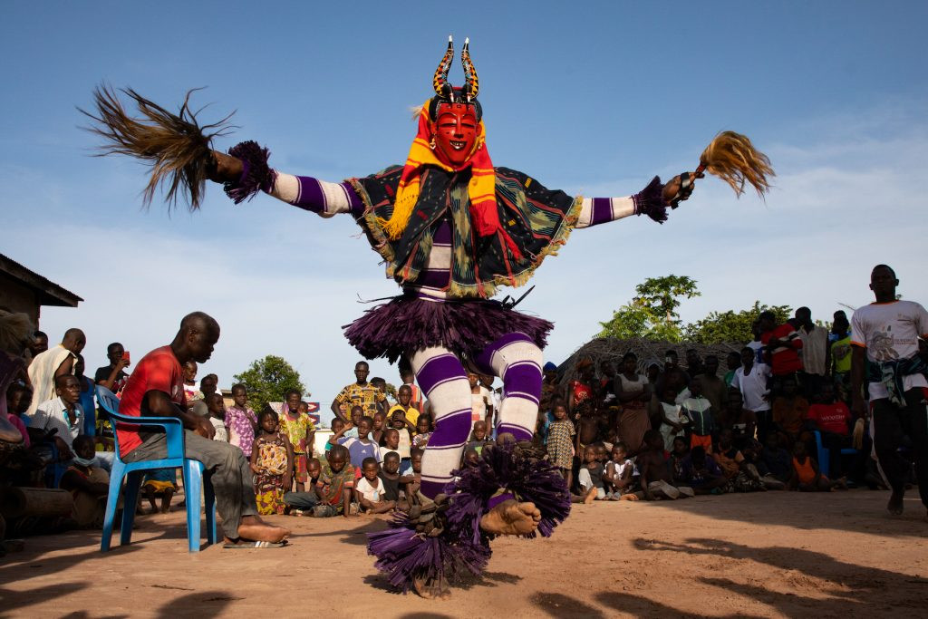 Dynamic Zaouli Gan Dance in Bouaflé, Ivory Coast: Observe the powerful and unique movements of a Zaouli dancer wearing the Gan mask during a captivating performance.