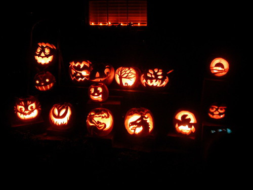 A family carving pumpkins together at a table, illustrating a pumpkin carving activity