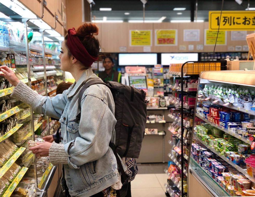 American dancer picking up snacks at a Japanese konbini for energy