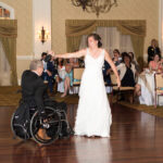 Quadriplegic man in a manual wheelchair dancing with his daughter at her wedding