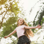 Young girl dancing freely in a brightly lit studio, embodying the joy of movement and self-expression.