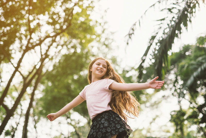 Young girl dancing freely in a brightly lit studio, embodying the joy of movement and self-expression.