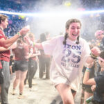 Enthusiastic crowd of diamond dancers participating in the THON line dance at Penn State.