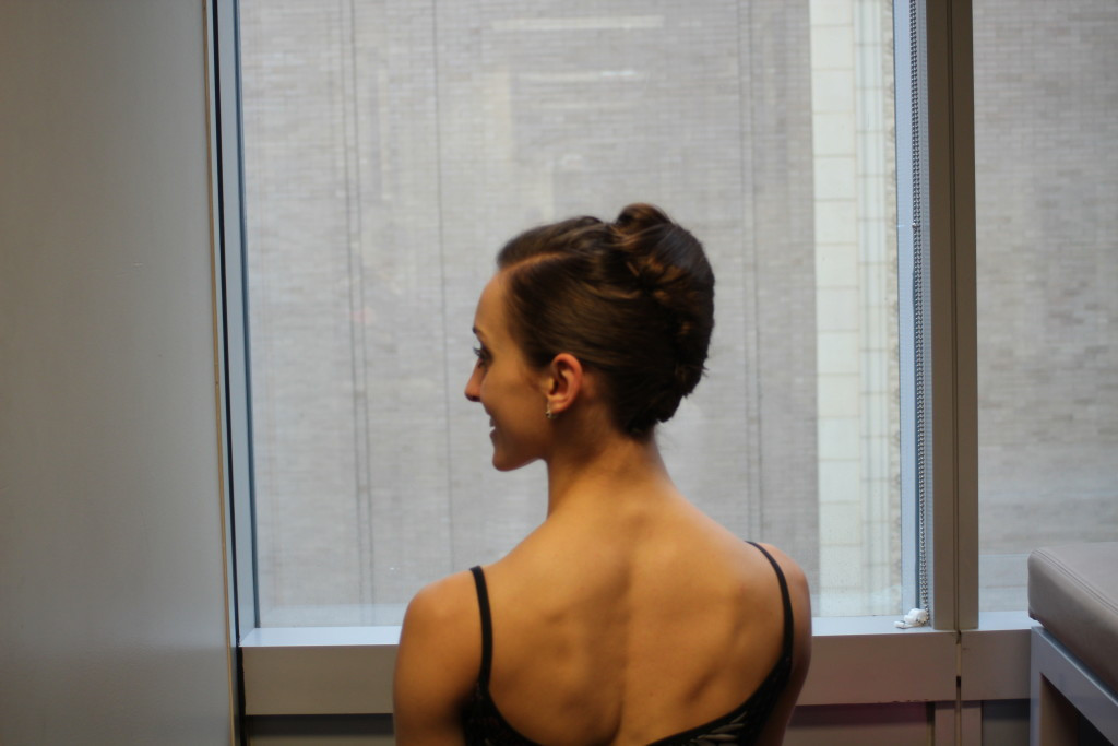 Final hairspray touch, symbolizing the finishing flourish of a dance performance