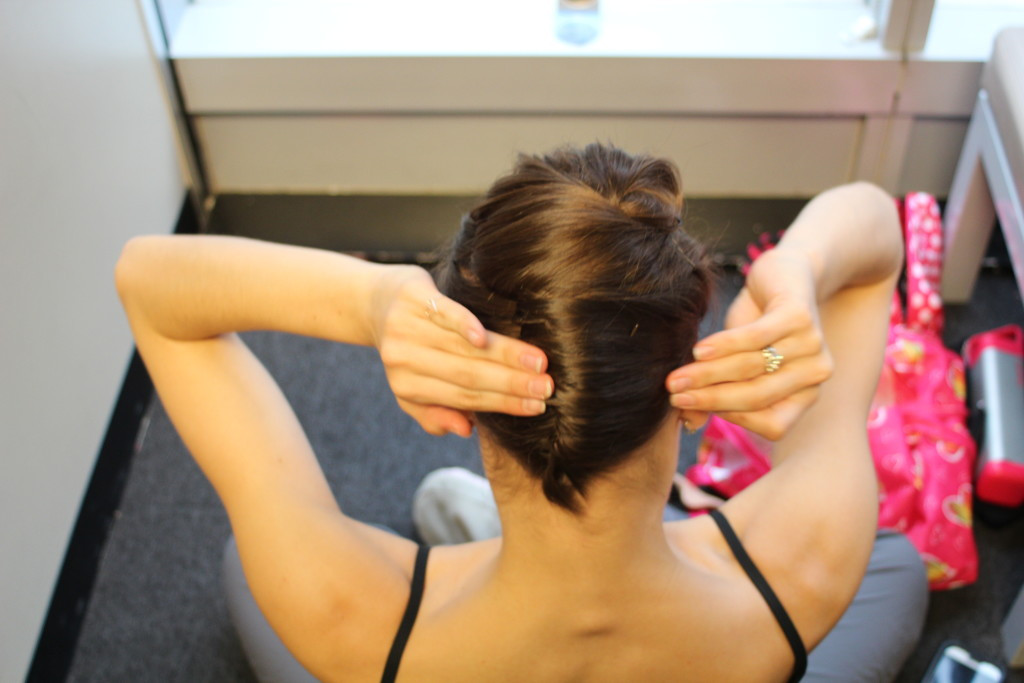 Hairpins securing a complex twist, representing the mastery of intricate dance moves