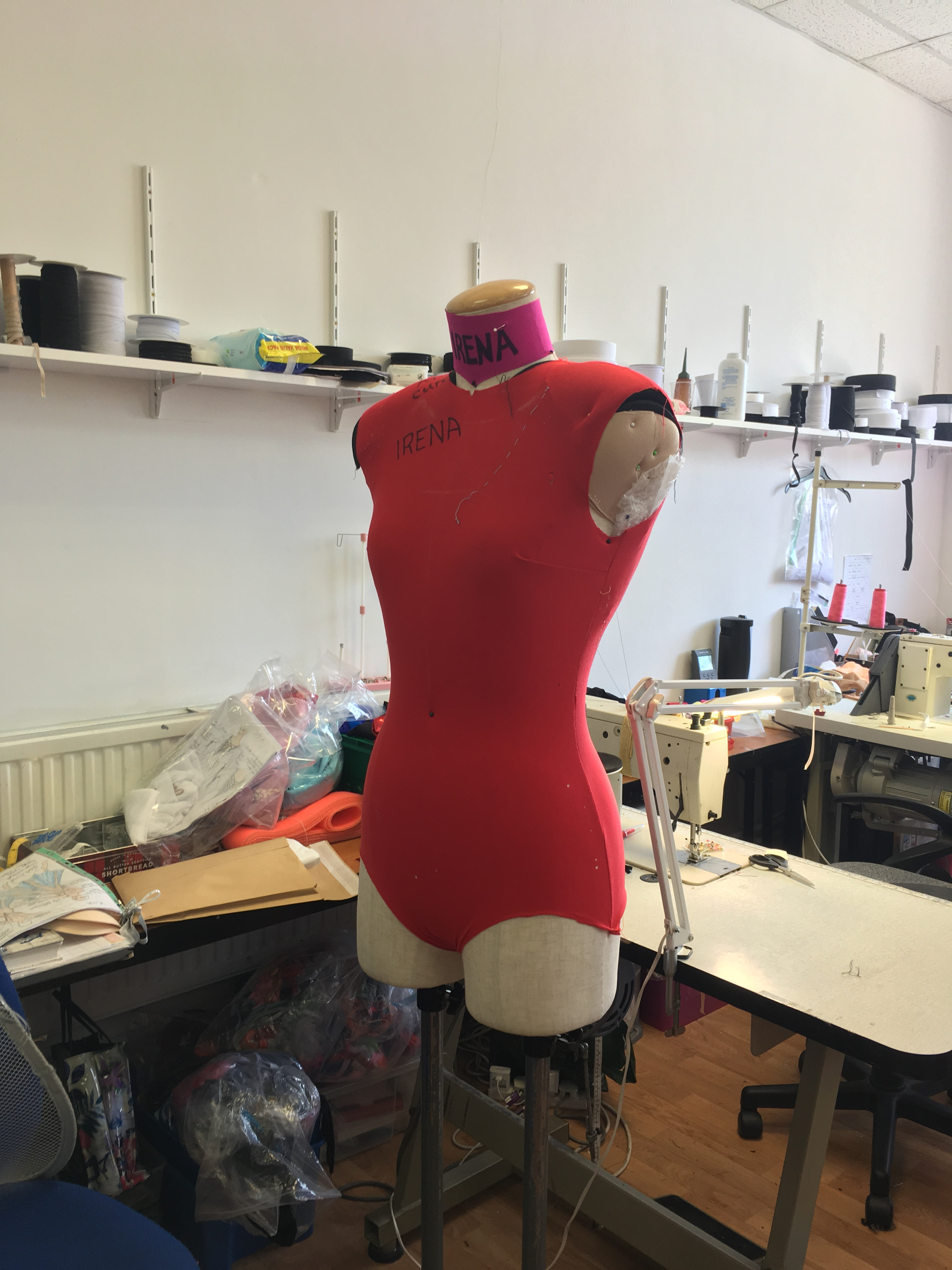 A client trying on a dance costume with a longer skirt, indicating customization and client-specific adjustments during the fitting process.