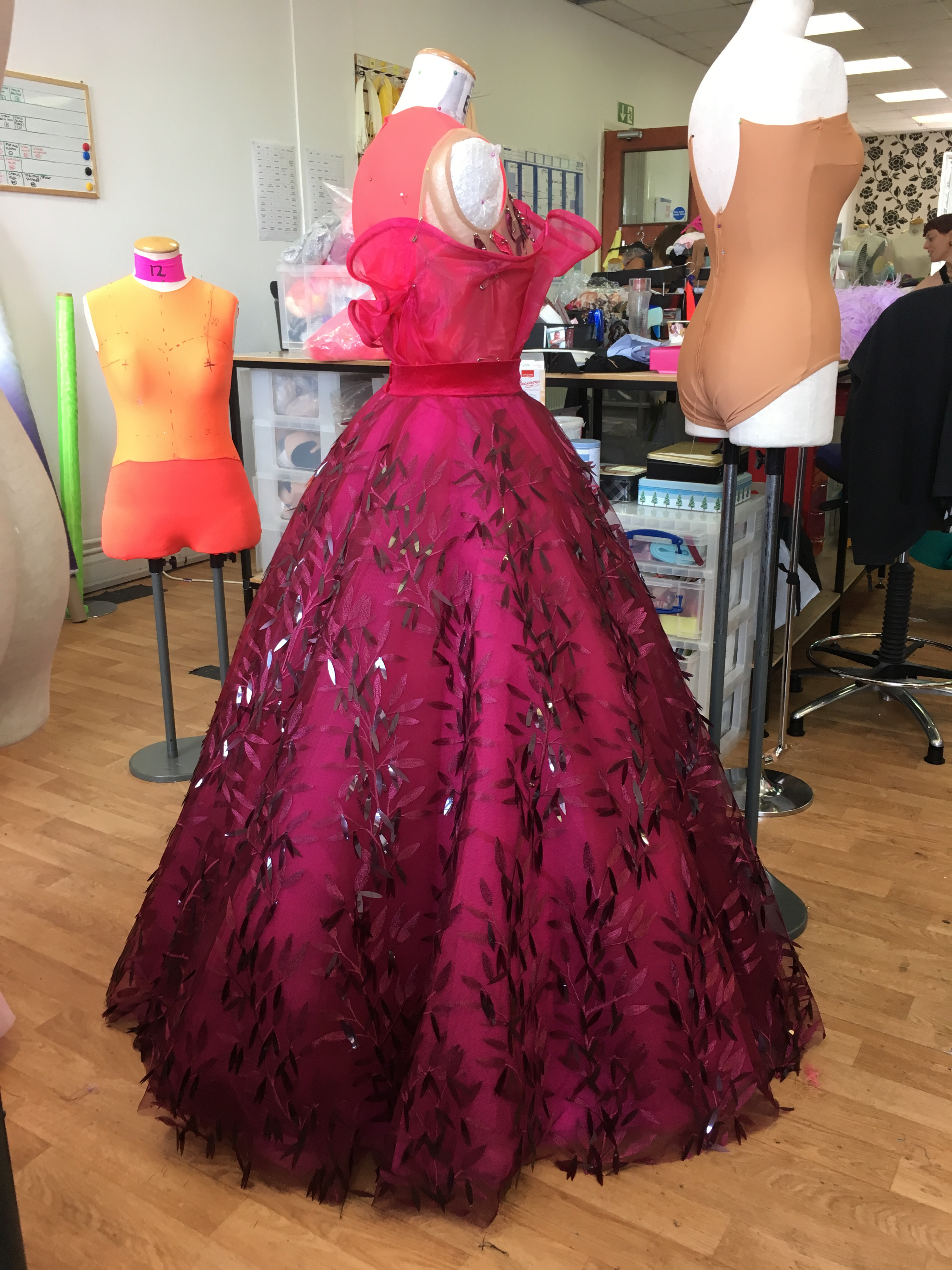 Close-up on the fabric of a dance costume skirt with large 'pailettes,' emphasizing the luxurious and eye-catching materials used in high-end dancewear.