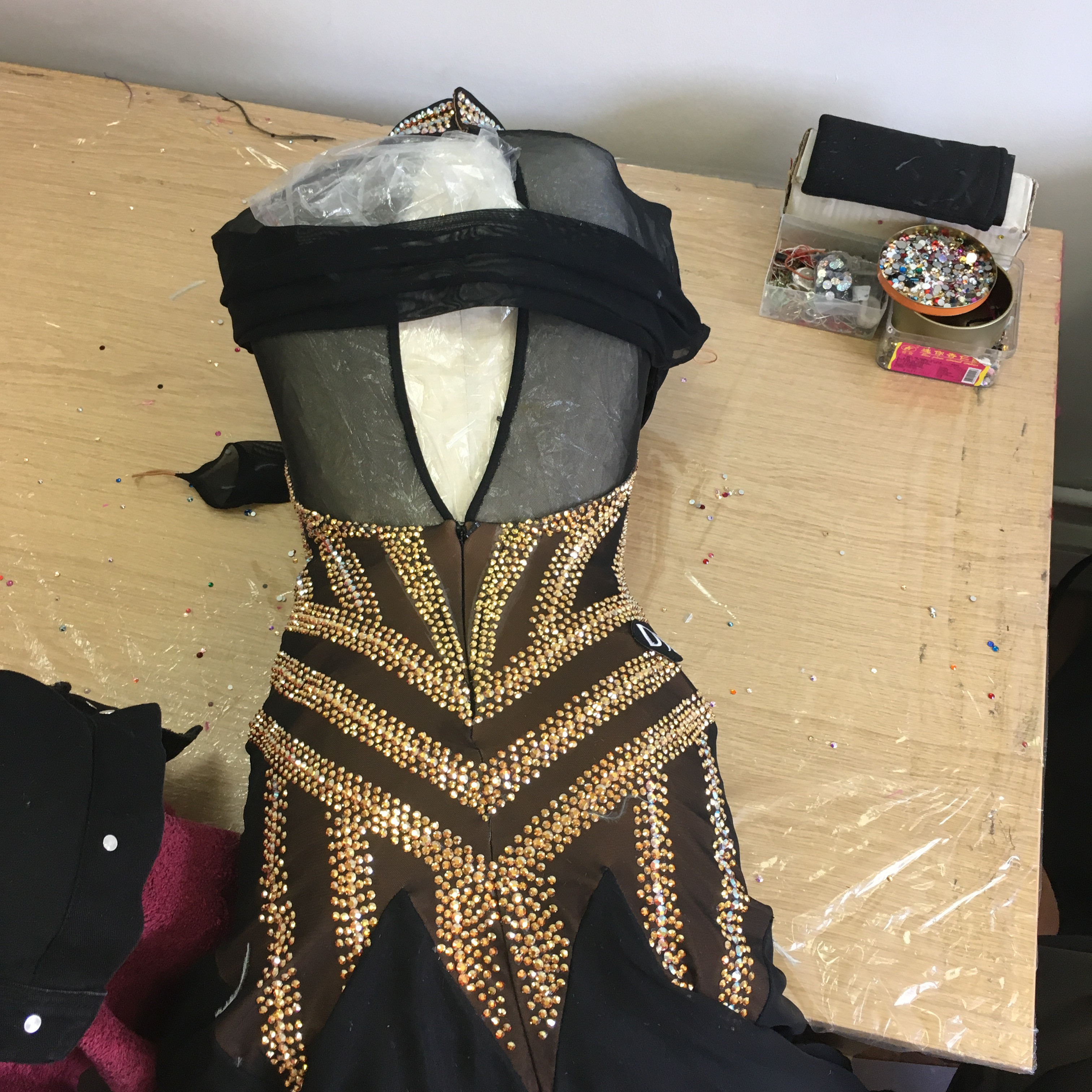Close-up of intricate stoning work on a dance costume, showcasing the painstaking process of adding sparkle and detail.