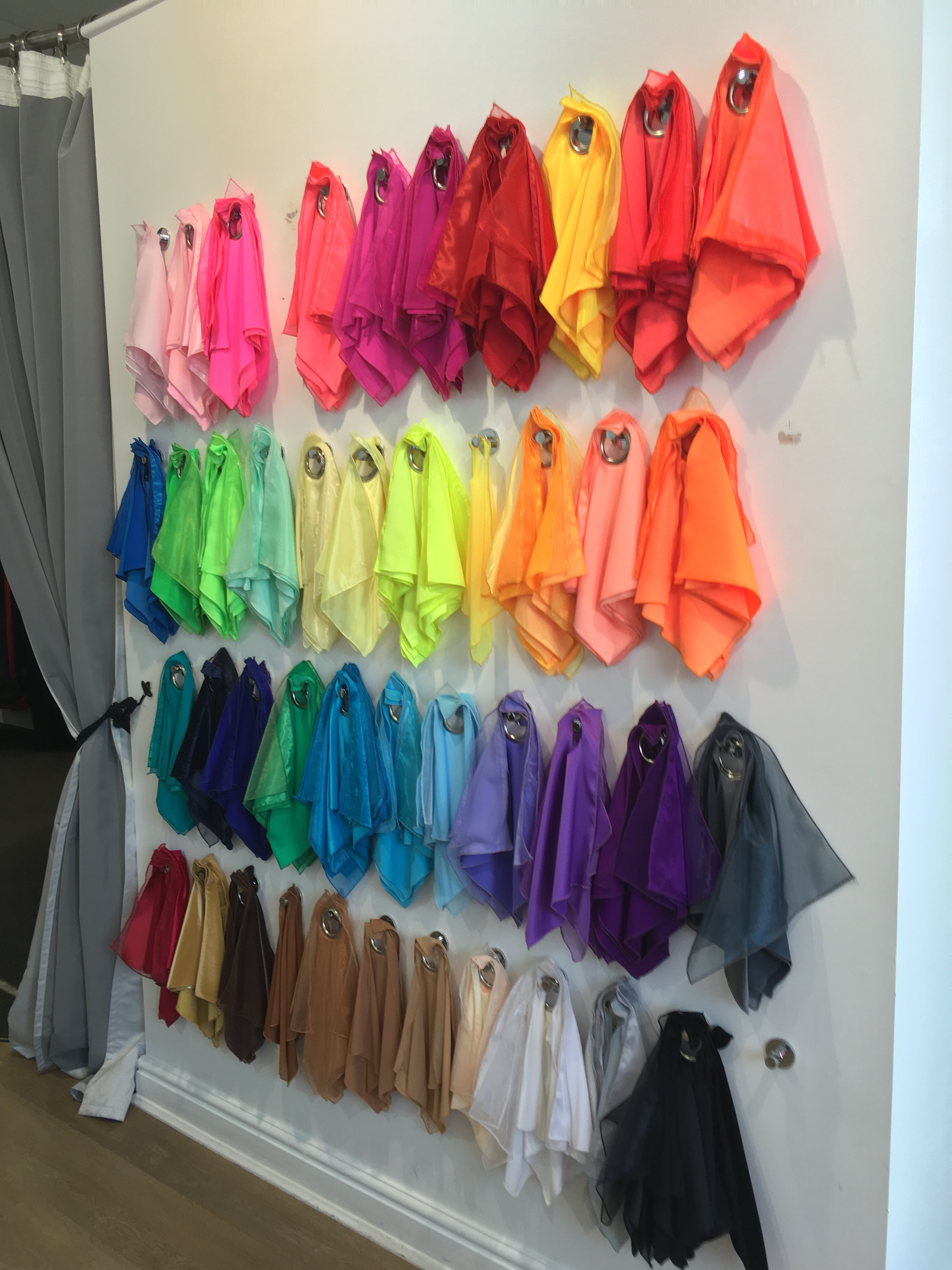 An array of colorful fabrics, a glimpse into the vast selection available for creating custom dance costumes, showcasing the variety of textures and shades.