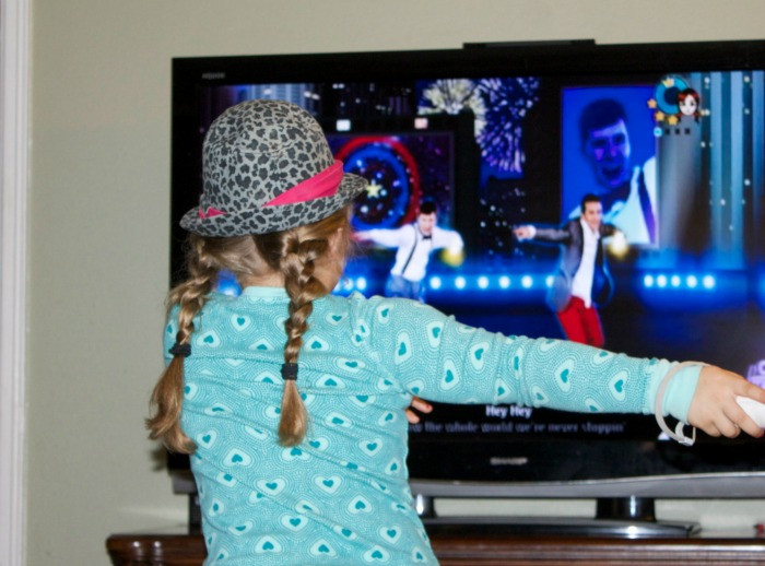 Girl energetically dancing to Just Dance Disney Kids Party, emphasizing the fitness aspect and enjoyment for children.