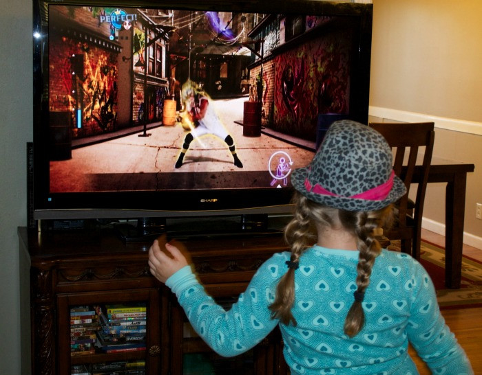 Family having fun playing Just Dance for kids fitness, promoting family activity and healthy entertainment.