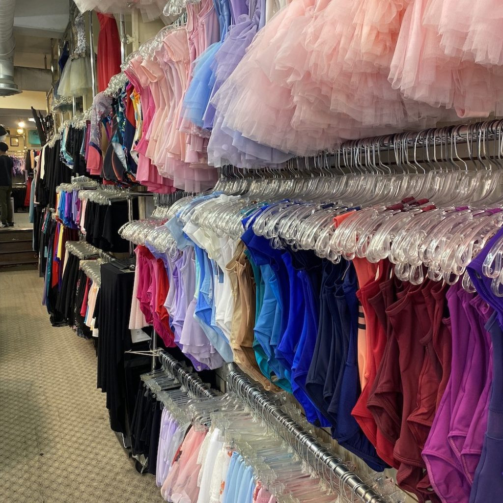 Shelves filled with leotards and skirts, showcasing the variety of dancewear at On Stage Dancewear.