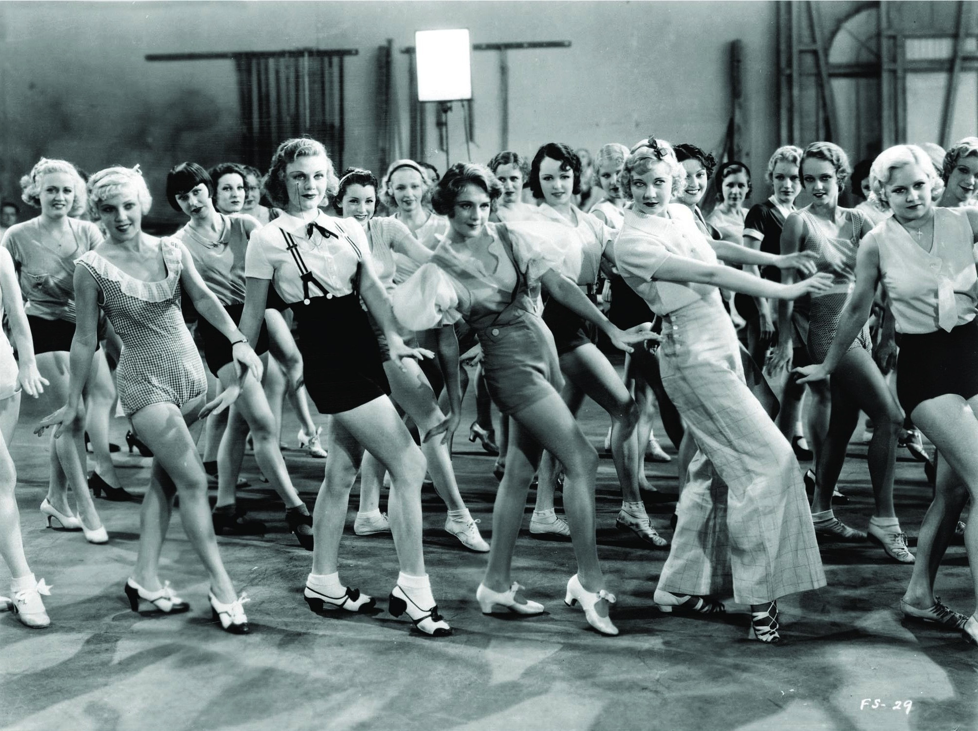 Publicity shot of Ruby Keeler as Peggy Sawyer and Dick Powell as Billy Lawler, representing the youthful romance and ambition in the 'dance street film' narrative.