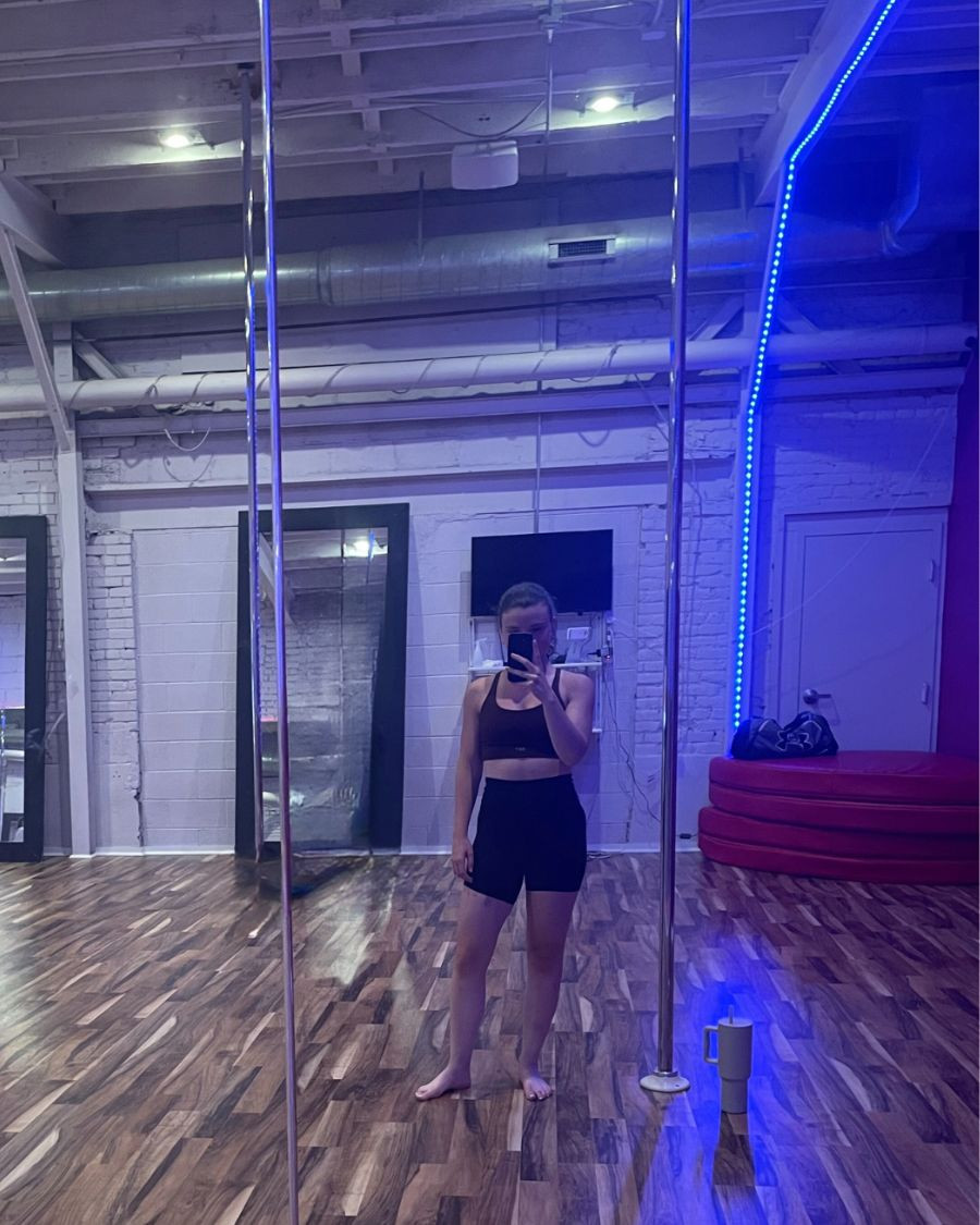 Participants in a pole dancing exercise class practicing spins and poses