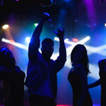 Man dancing in a club with confidence and rhythm, showcasing basic steps like the two-step, bounce, side-to-side rock, and triangle step, embodying the essence of rhythm and confidence in club dancing.