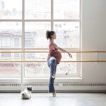 A pregnant dancer in a supportive pose, showcasing the strength and grace of dancing during pregnancy.