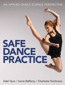 A dancer stretching her legs on a wooden barre